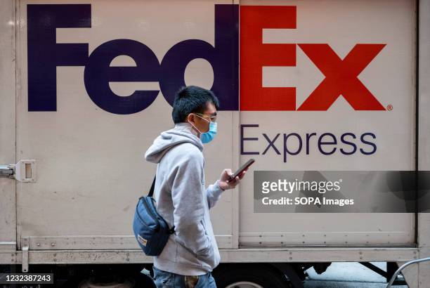Man walks past the American FedEx Express delivery truck seen in Hong Kong.