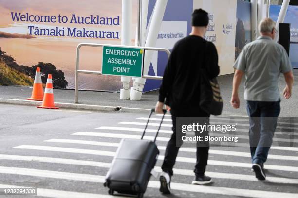 Traveler crosses a road at Auckland International Airport in Auckland, New Zealand, on Monday, April 19, 2021. Australia and New Zealand on Monday...