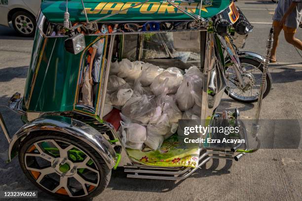 Plastic bags containing rice to be given away are seen aboard a tricycle at the Maginhawa community pantry on April 19, 2021 in Quezon city, Metro...