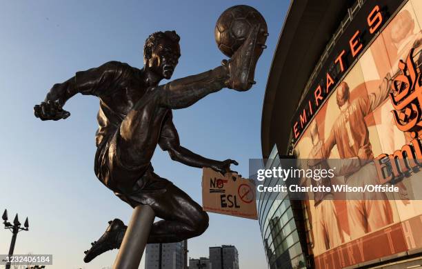 April 2021: A sign protesting the European Super League has been taped to the hand of the Dennis Bergkamp statue outside The Emirates Stadium on...