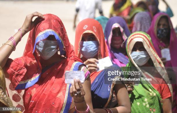 Women show voter ID cards during Panchayat election, at Bakkas polling centre on April 19, 2021 in Lucknow, India.