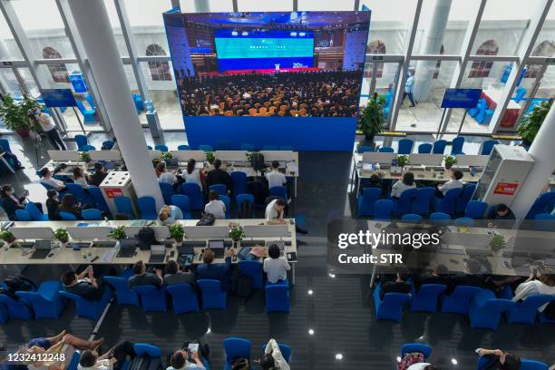 Journalists watch a screen showing the opening of the Boao Forum for Asia Annual Conference 2021 in Boao, south China's Hainan province on April 20,...