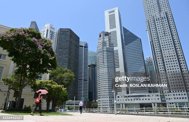 Woman walks along a promenade at the Raffles Place financial business district in Singapore on April 20, 2021.