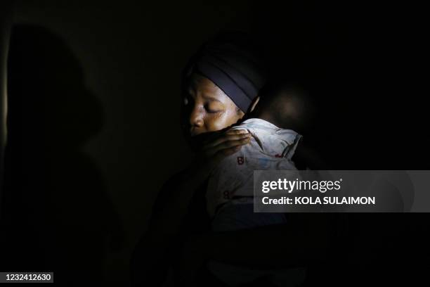 Amina Ahmed, wife of Mubarak Bala, an outspoken atheist who was charged with blasphemy, comforts her 1-year-old baby at their home in Abuja, Nigeria,...