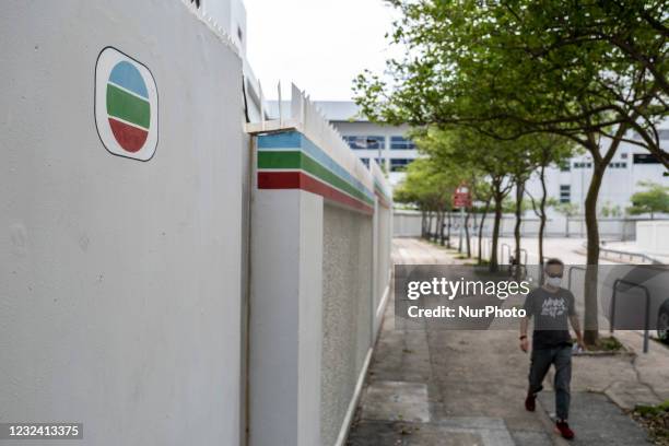 Man walks pass the wall surrounding TVB City, which is where the Hong Kong Broadcaster Television Broadcasts Limited is located in Hong Kong, China...