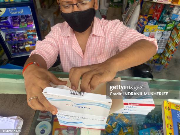 Staff member sorts Fabiflu tablets, an anti-viral medicine containing favipiravir and used to treat mild to moderate Covid-19 cases, at a chemist in...