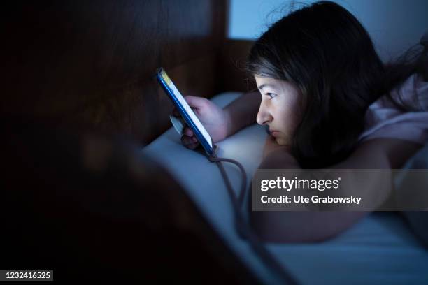 Bonn, Germany In this photo illustration a girl looks at the screen of her smartphone on April 16, 2021 in Bonn, Germany.