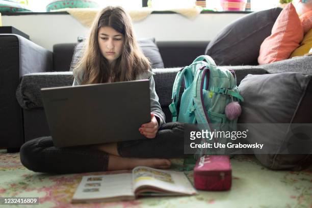 Bonn, Germany In this photo illustration a girl sits in a livingroom doing her homework on April 16, 2021 in Bonn, Germany.