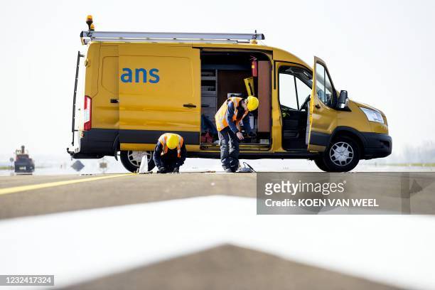 Heijmans construction company personnel operate works on the Polderbaan at Schiphol airport, near Amsterdam, on April 20, 2021. - The runway at...