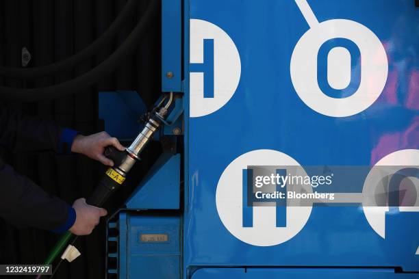 Worker refuels a Coradia iLint hydrogen fuel cell powered prototype railway train, manufactured by Alstom SA, at a refueling station in Salzgitter,...