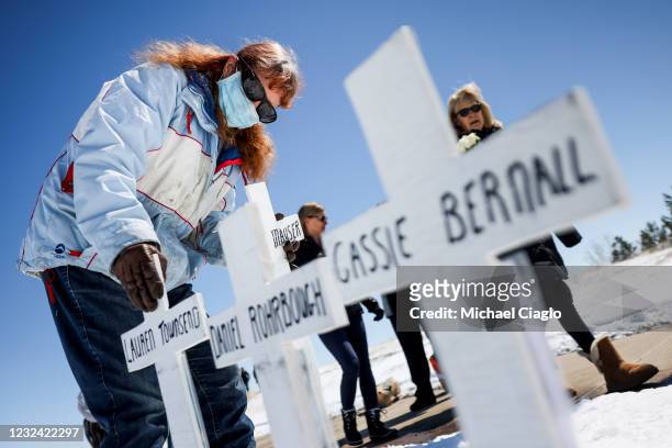 Rhonda Grindle places crosses with the names of the victims of the Columbine High School shooting next to the Columbine Memorial on April 20, 2021 in...