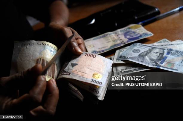 Man exchanges Nigeria's currency Naira for US dollars in Lagos, Nigeria, on April 19, 2021. - Nigeria's economy was already struggling with a fall in...