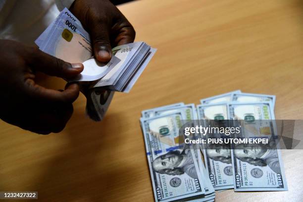 Man exchanges Nigeria's currency Naira for US dollars in Lagos, Nigeria, on April 19, 2021. - Nigeria's economy was already struggling with a fall in...