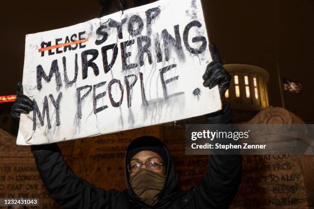 Black Lives Matter activist holds a sign against police brutality in front of the Ohio Statehouse in reaction to the shooting of Makiyah Bryant on...