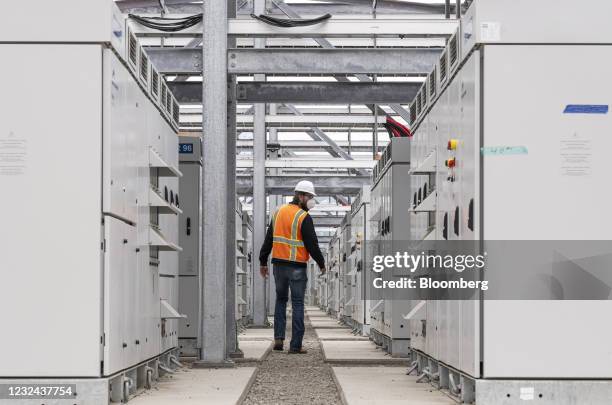 Worker walks between power inverters outside the battery building at the Vistra Corp. Moss Landing Energy Storage Facility in Moss Landing,...