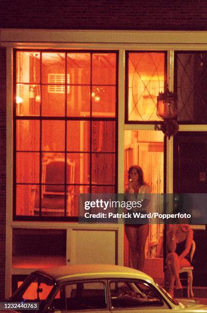 Sex workers posing outside houses in the Red Light District in Amsterdam, circa July 1976.