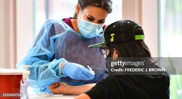 Phlebotomist Briana Green draws blood during the new FDA emergency use and authorized IgG ll Antibody Test for vaccinated people being offered free...