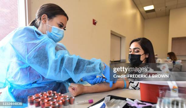 Phlebotomist Briana Green draws blood from Maritza Nieves during the new FDA emergency use and authorized IgG ll Antibody Test for vaccinated people,...