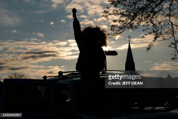 Woman holds up her fist out of the roof of a vehicle during a vigil in Columbus, Ohio on April 21, 2021 to remember MaKhia Bryant who was shot and...