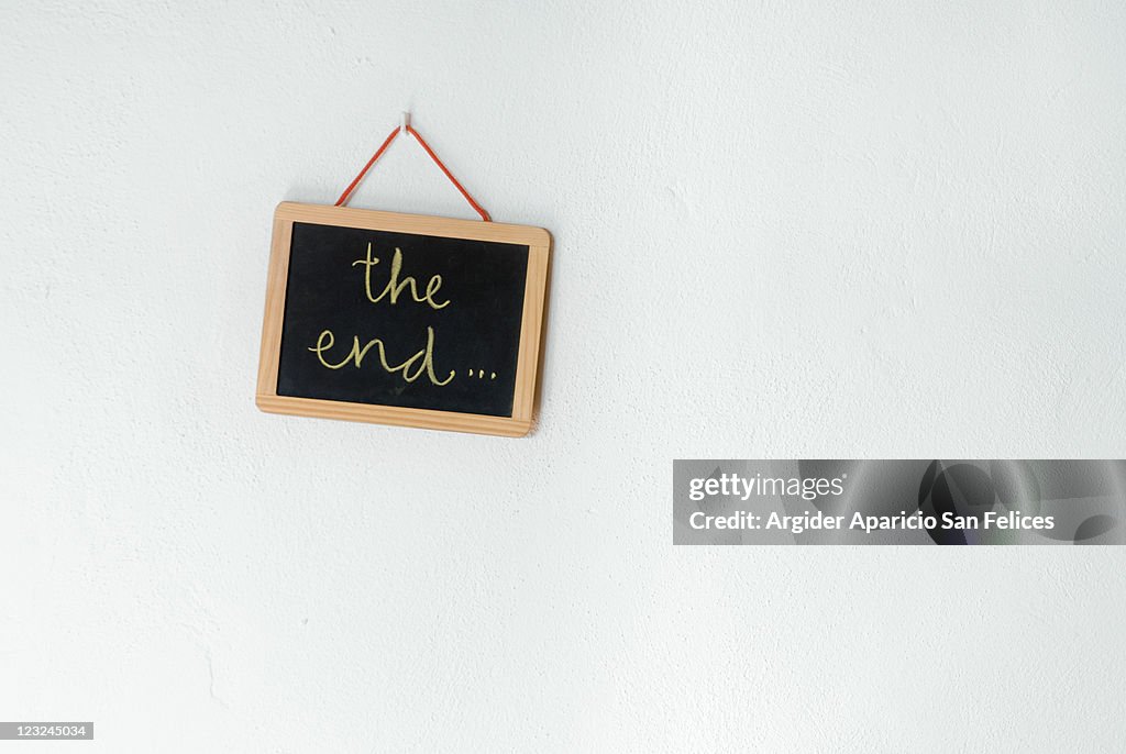 The end written on slate which is hanging on wall
