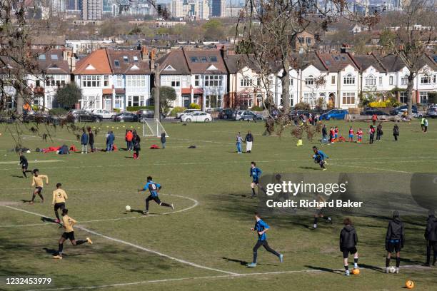 With the wider city in the distance, youth teams play a football match in a south London park, on 17th April 20231, in London, England.