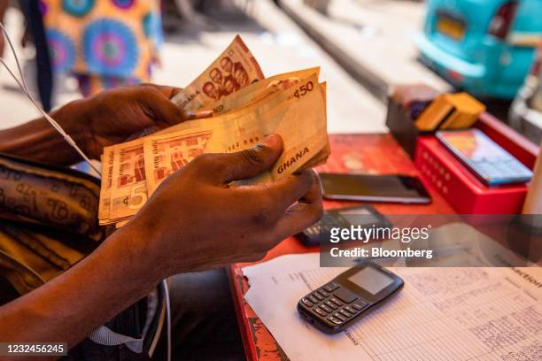 Vendor counts Ghana cedi banknotes during a mobile money transaction at a kiosk in Accra, Ghana, on Tuesday, April 22, 2021. MTN Group Ltd. Values...