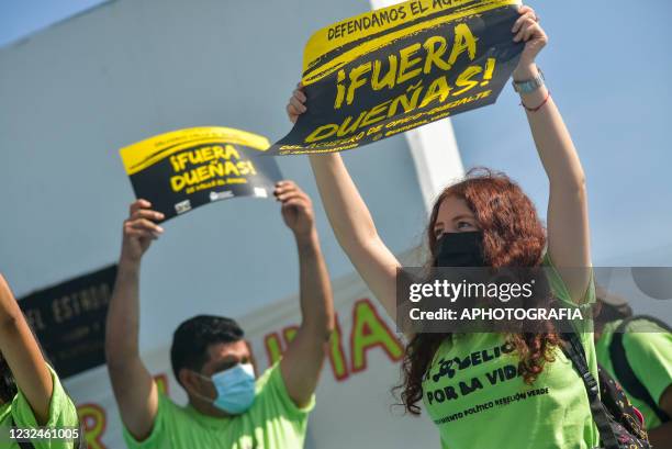 Activists hold up signs against the construction of a commercial complex that received a water relief contract as part of global action to combat...