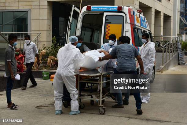 Hospital staffs and health workers transfer a Covid-19 patient from an Ambulance to a stretcher for his admission in a government hospital, Kolkata,...