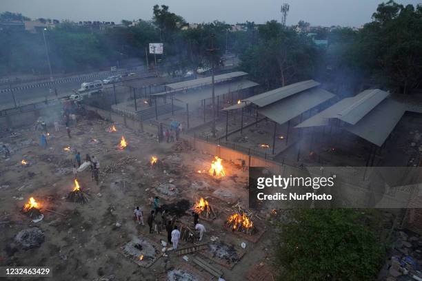 View of a crematorium ground showing funeral pyres during a mass cremation of victims, who died due to the coronavirus disease , at a crematorium in...