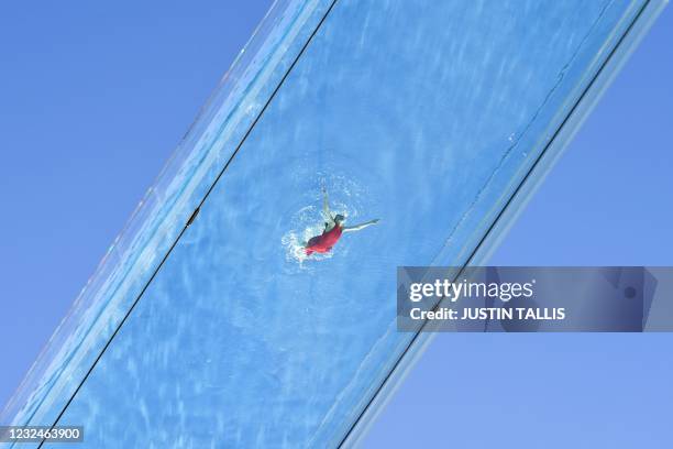 Model swims in a transparent acrylic swimming pool bridge that is fixed between two apartment blocks at Embassy Gardens next to the new US Embassy in...