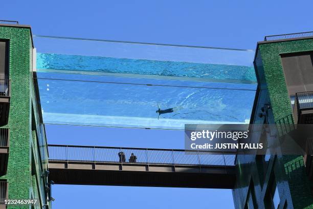 Model swims in a transparent acrylic swimming pool bridge that is fixed between two apartment blocks at Embassy Gardens next to the new US Embassy in...