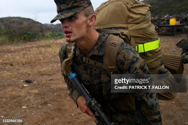 Blood drips from the mounth of a United States Marine Corps recruit from Lima Company, the first gender integrated training class in San Diego as he...