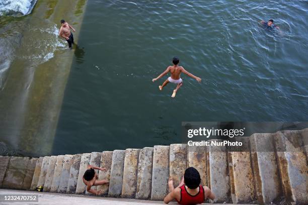 Children swim in the Nile River during hot weather in the Qanater area on the outskirts of Cairo, before the sunset call to prayer in the holy month...