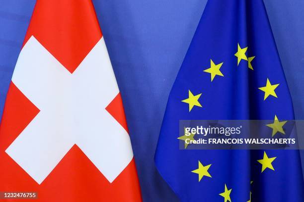 This photograph taken on April 23, 2021 shows Switzerland's national flag and te European Union flag at the European Commission building in Brussels.