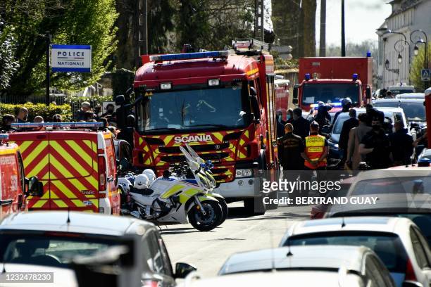 French police officials and firefighters stand outside the police station in Rambouillet, south-west of Paris, on April 23 after a woman was stabbed...