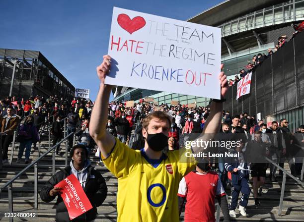Arsenal fans hold placards during a protest against the club's owner Stan Kroenke ahead of the Premier League match between Arsenal and Everton,...