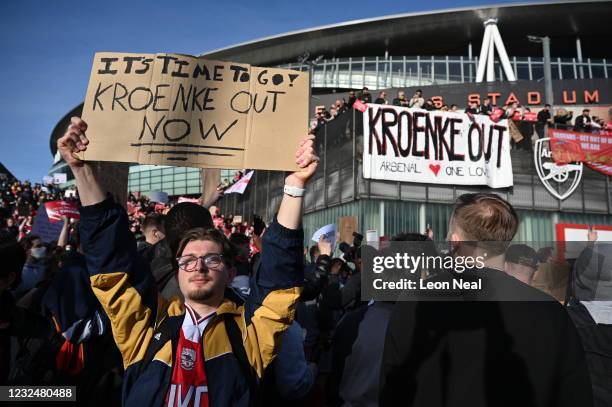 Arsenal fans hold placards during a protest against the club's owner Stan Kroenke ahead of the Premier League match between Arsenal and Everton,...