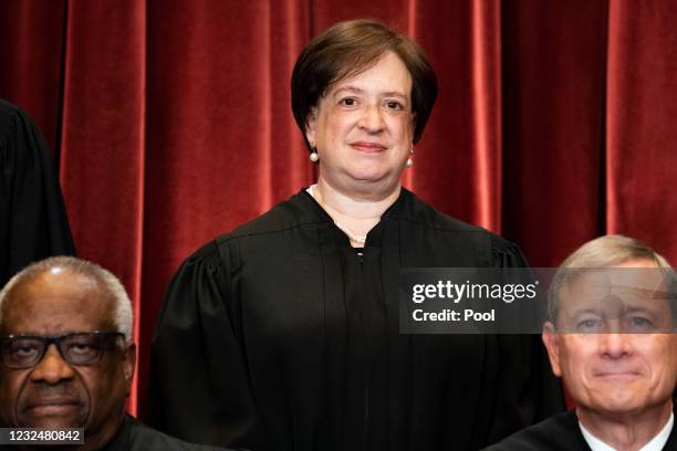 Associate Justice Elena Kagan, with Associate Justice Clarence Thomas and Chief Justice John Roberts in front of her, stands during a group photo of...