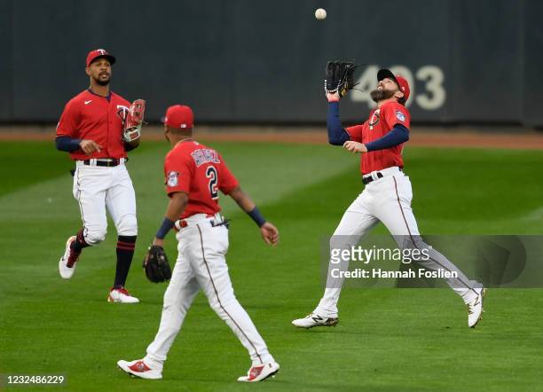 Byron Buxton and Luis Arraez of the Minnesota Twins look on as Jake Cave makes a catch in right field of the ball hit by Adam Frazier of the...