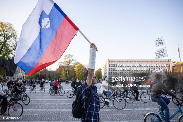Protester carries the Slovenian flag during an anti-government protest in Ljubljana. Protests against the government of Janez Jansa in Slovenia...