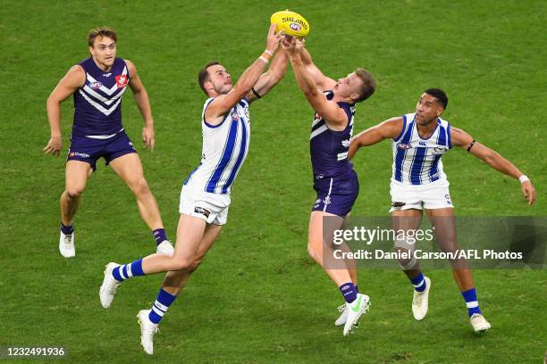 Josh Walker of the Kangaroos competes for the ball with Josh Treacy of the Dockers uring the 2021 AFL Round 06 match between the Fremantle Dockers...