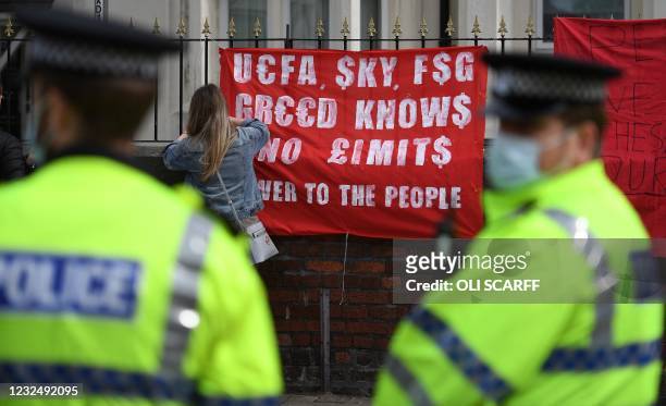 Police officer stands on duty as supporters protest against Liverpool's US owner John W. Henry and the Fenway Sports Group outside English Premier...
