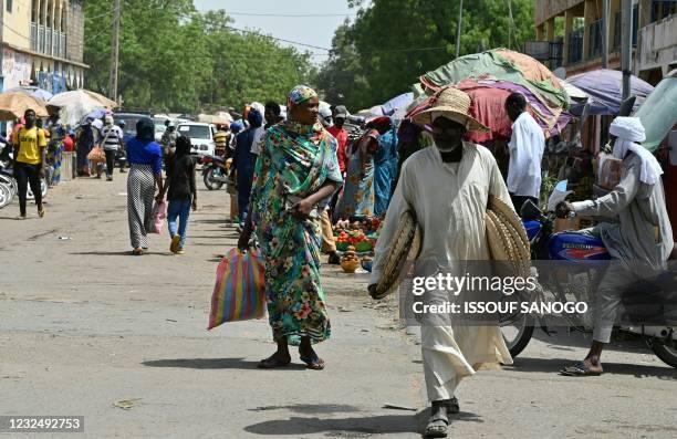 People walk in the market of N'djamena on April 23 the day of Chad late president Idriss Deby funeral. - Chad's President Idriss Deby died on April...