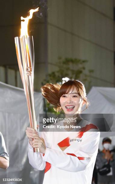 Talent Rino Sashihara runs for the Tokyo Olympic torch relay in Oita, southwestern Japan, on April 24, 2021.