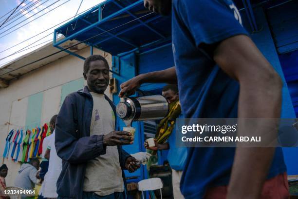 An activists of the opposition Senegalese party 'Pastef' distributes free coffee to break the fast during the holy month of Ramadan in the Medina...