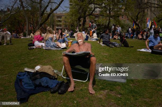 Man uses a reflector as he sunbathes in a park in Manhattan, New York on April 24, 2021.