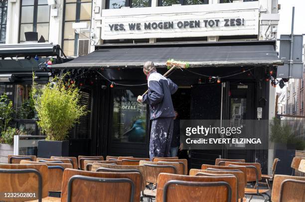 Employee cleans a terrace on the Amstel in Amsterdam on April 24 after the Dutch cabinet decided that the terraces for outdoor services can reopened...