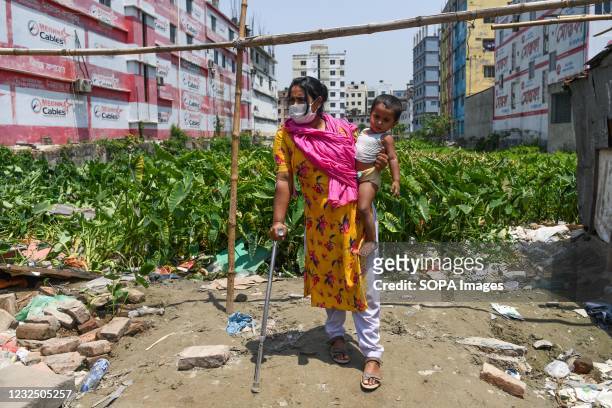Yanur Islam, an injured garment worker who survived poses with her child at the site during the eighth anniversary of the Rana Plaza building...