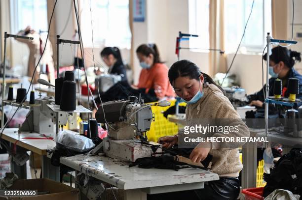 This photo taken on March 25, 2021 shows workers sewing at a lingerie factory in Guanyun county, some 50 kilometres from Lianyungang in China's...