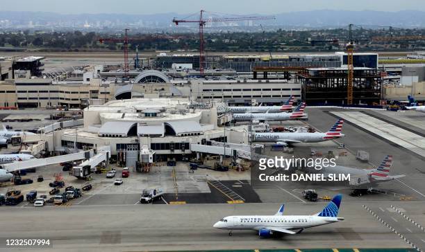 United Express plane drives by the American Air Lines hub at Los Angeles International Airport on April 24, 2021.
